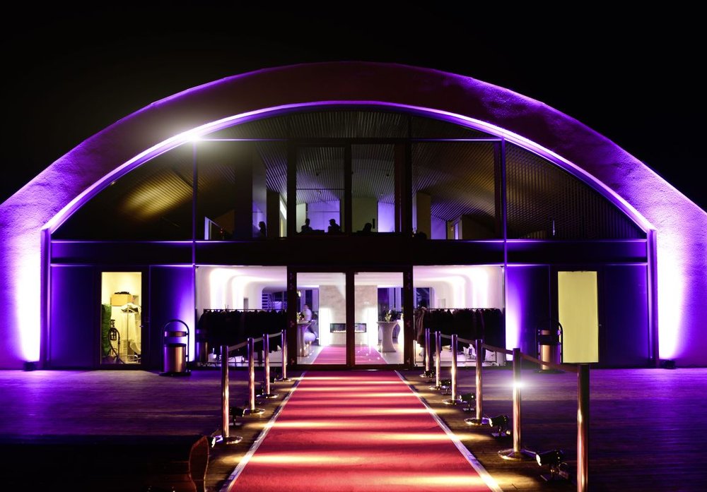 Außenansicht einer Hochzeitslocation mit architektonischer Lichtinszenierung als bewusster Rahmen für eine außergewöhnliche Hochzeit
