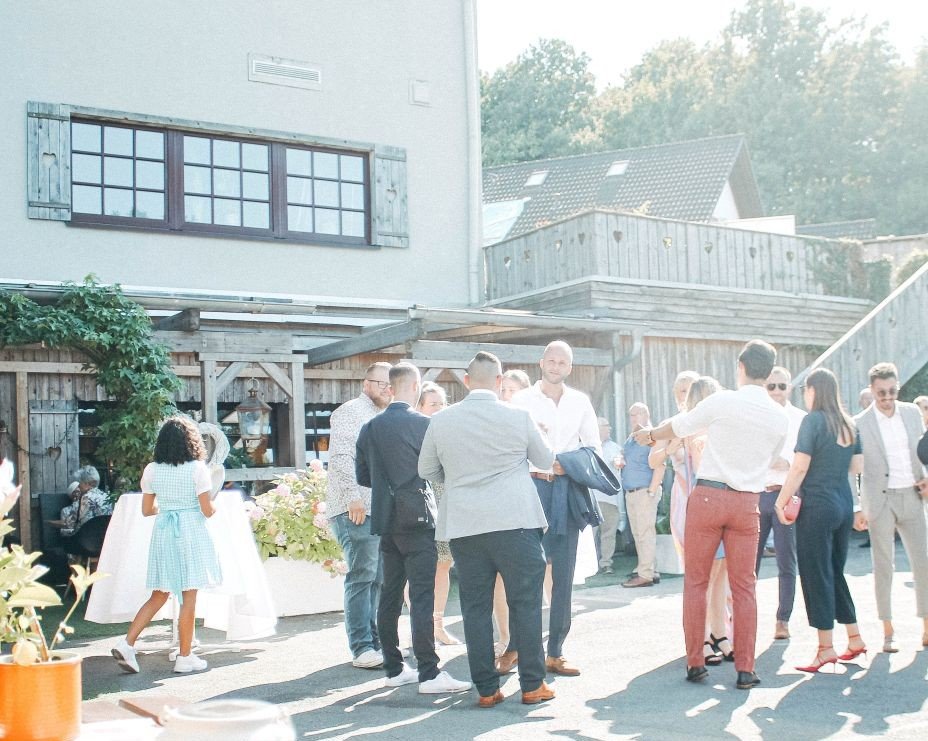 Hochzeitsgäste beim Sektempfang im Freien vor der Hochzeitslcoation Sportalm Gipfelglück in Lüdenscheid