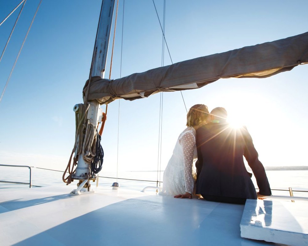 Brautpaar auf einem Schiff bei Sonnenuntergang – romantische Stimmung auf dem Wasser