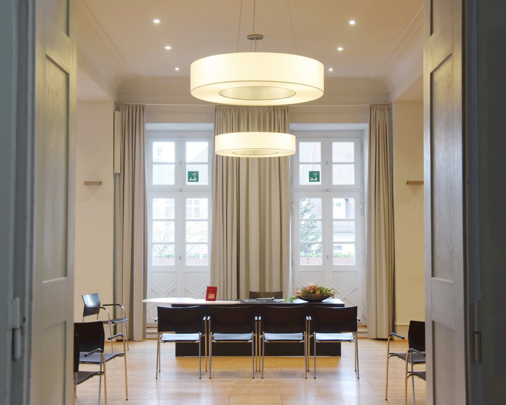 Einladender Blick durch eine graue Flügeltür in den hellen Bürgersaal im Rathaus Durlach – ein eleganter Raum des Stadtamts Durlach für feierliche standesamtliche Trauungen.
