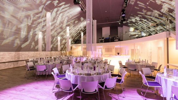Hochzeitssaal mit festlicher Bestuhlung und Lichtkonzept in der Hochzeitslocation E210 Eventhangar in Rheinmünster
