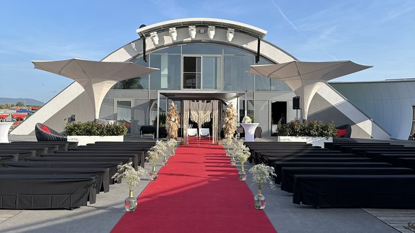 Ankunft der Hochzeitsgäste über den roten Teppich an der Hochzeitslocation E210 Eventhangar in Rheinmünster