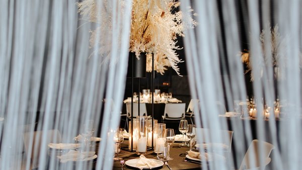 Stimmungsvolle Hochzeitsdekoration mit Vorhängen und Lichtakzenten in der Hochzeitslocation E210 Eventhangar in Rheinmünster