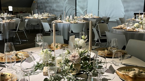 Festlich gedeckte Hochzeitstische mit Videowall in der Hochzeitslocation E210 Eventhangar in Rheinmünster