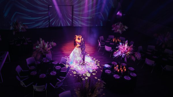 Inszenierter Hochzeitsmoment im Spotlight mit Lichtprojektionen in der Hochzeitslocation E210 Eventhangar in Rheinmünster