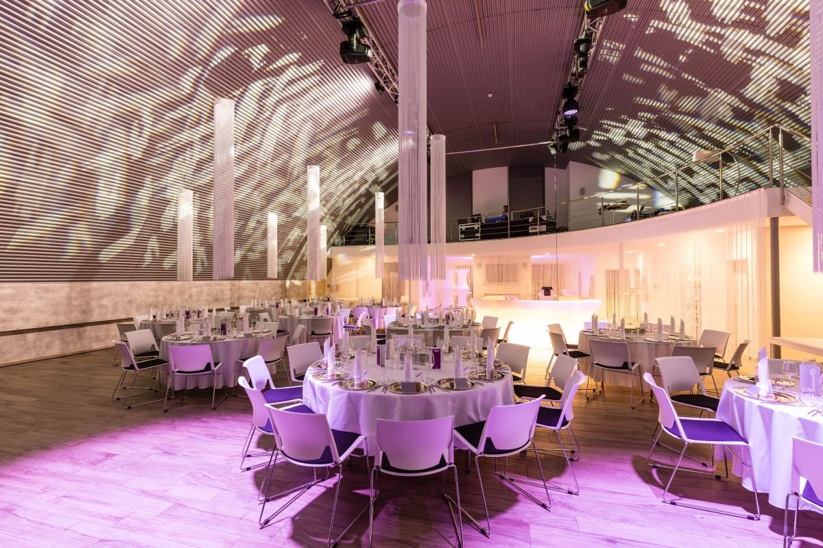 Hochzeitssaal mit festlicher Bestuhlung und Lichtkonzept in der Hochzeitslocation E210 Eventhangar in Rheinmünster