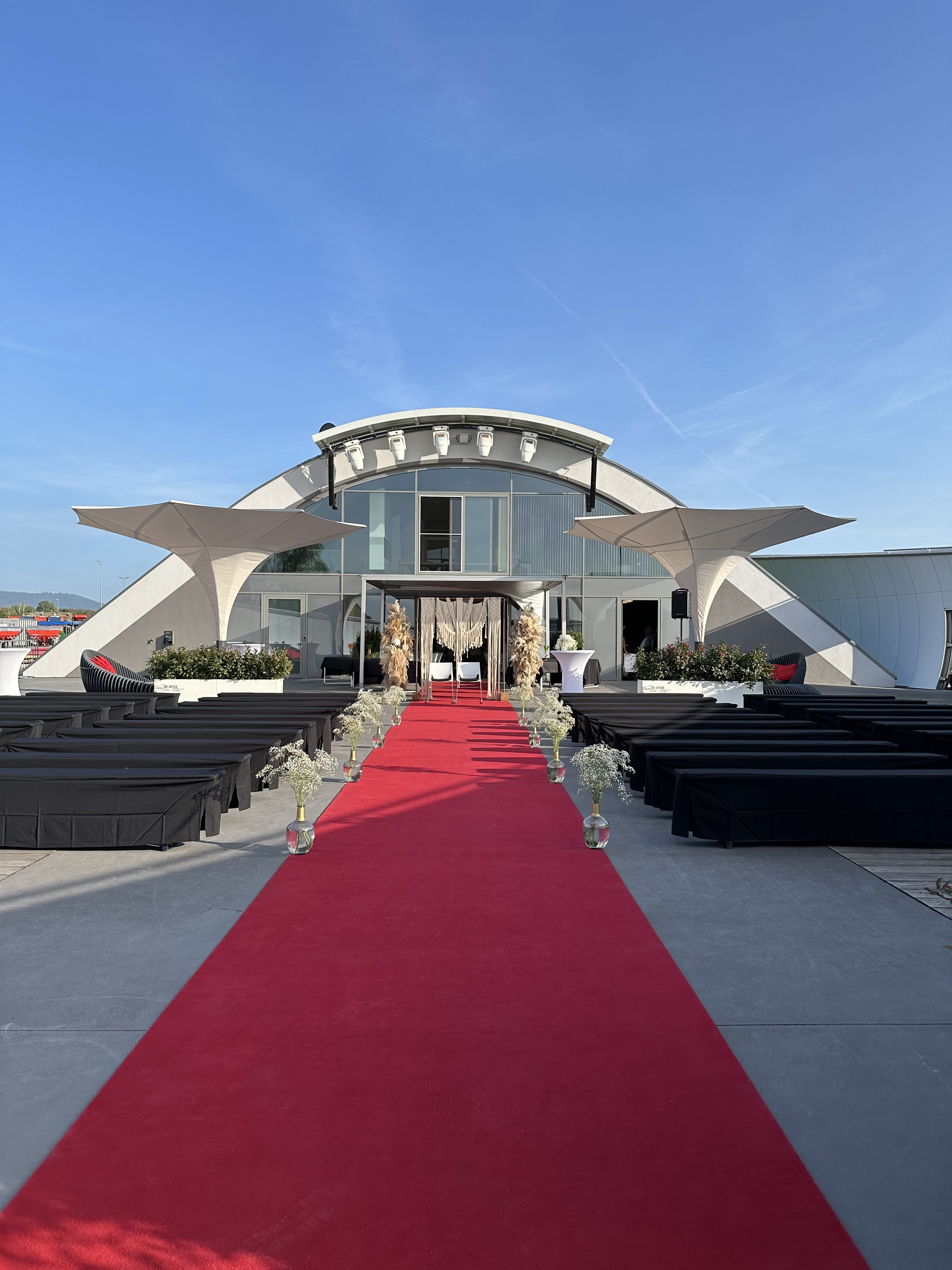 Ankunft der Hochzeitsgäste über den roten Teppich an der Hochzeitslocation E210 Eventhangar in Rheinmünster