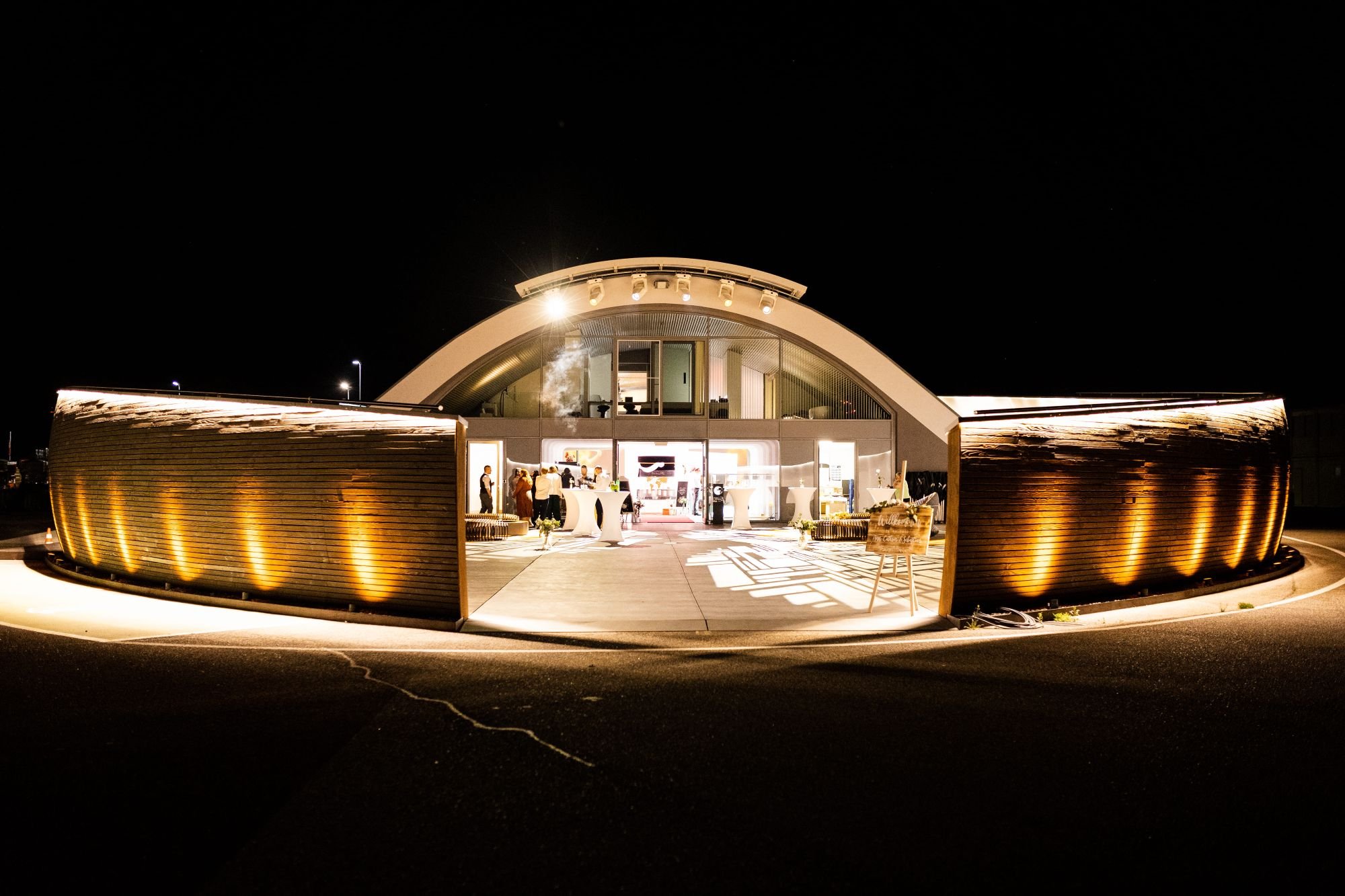 Außenansicht bei Nacht mit exklusiver Beleuchtung der außergewöhnlichen Hochzeitslocation E210 Eventhangar in Rheinmünster
