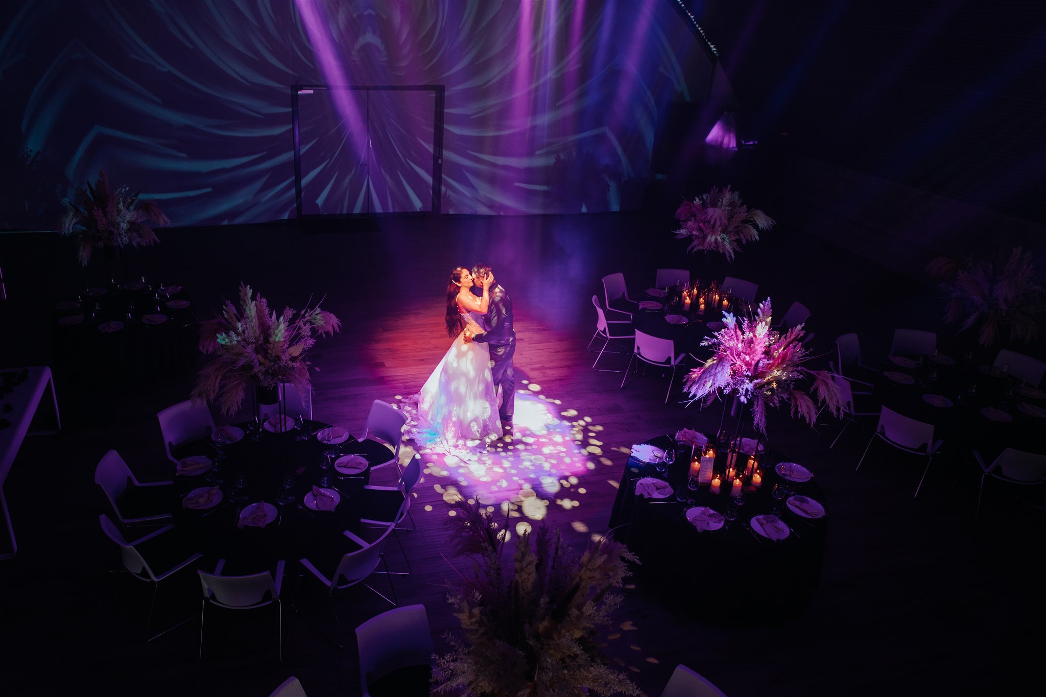 Inszenierter Hochzeitsmoment im Spotlight mit Lichtprojektionen in der Hochzeitslocation E210 Eventhangar in Rheinmünster