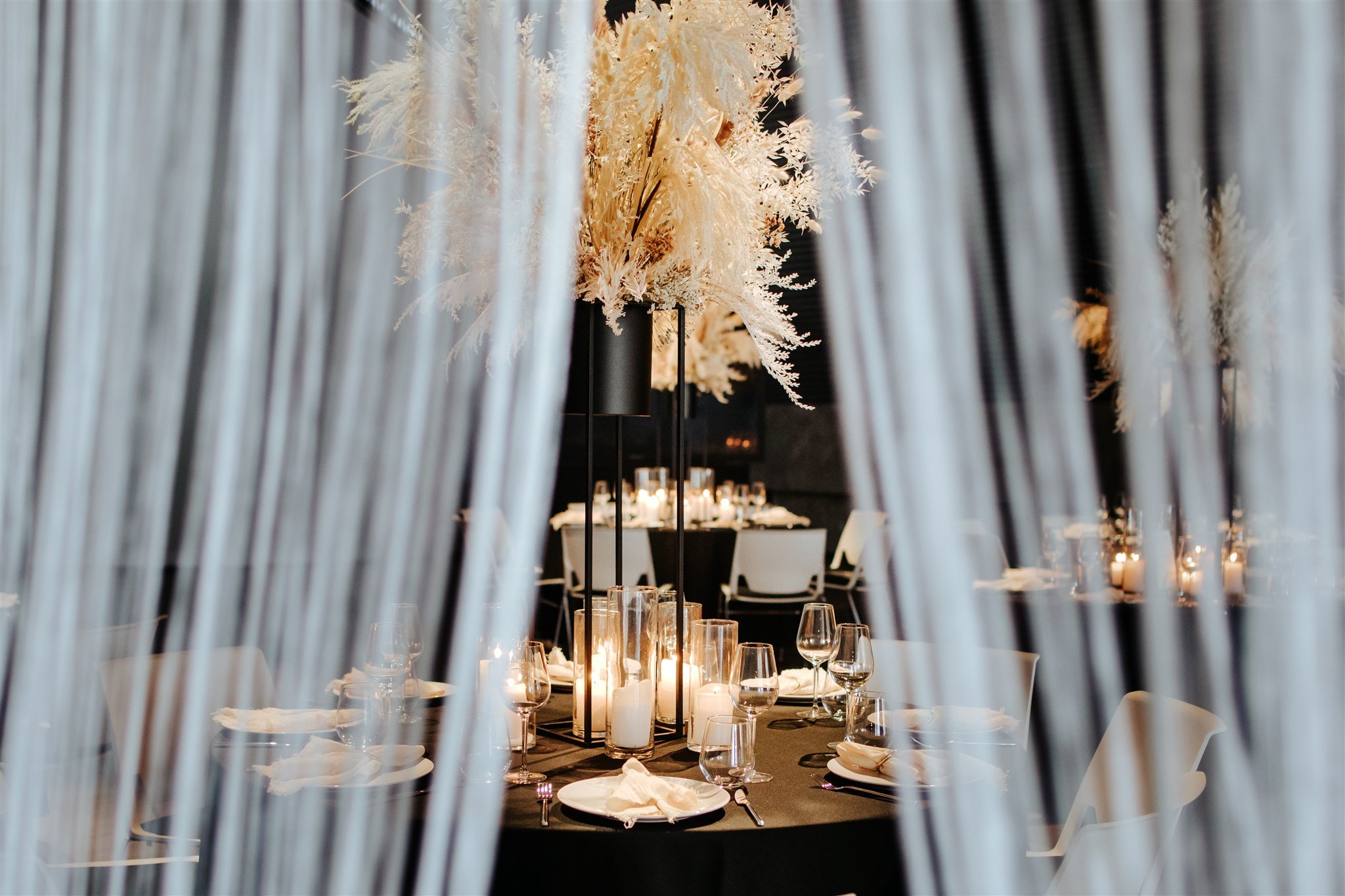 Stimmungsvolle Hochzeitsdekoration mit Vorhängen und Lichtakzenten in der Hochzeitslocation E210 Eventhangar in Rheinmünster