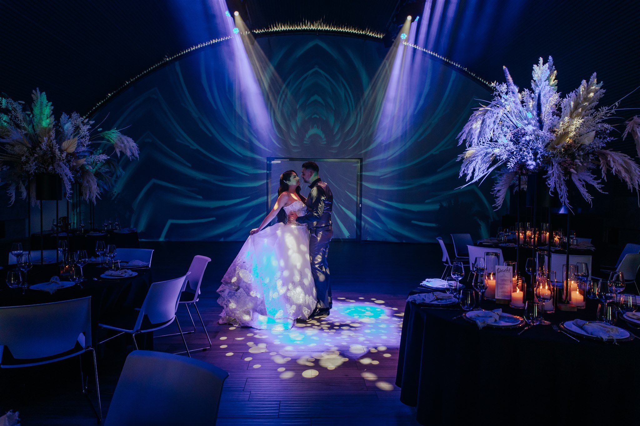 Brautpaar im Mittelpunkt einer modernen Hochzeitsinszenierung in der Hochzeitslocation E210 Eventhangar in Rheinmünster