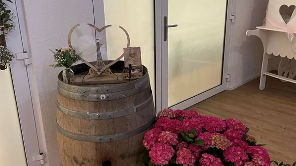 Detailaufnahme eines dekorativen Weinfasses mit Blumen im Eventhaus Boger.