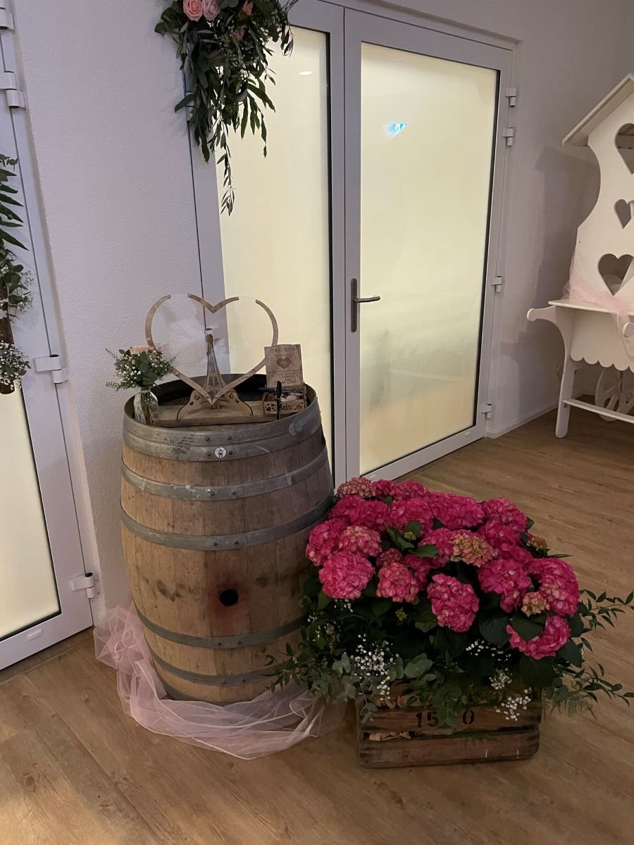 Detailaufnahme eines dekorativen Weinfasses mit Blumen im Eventhaus Boger.