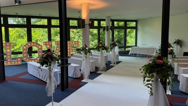 Freie Trauung im Wintergarten des Kurhauses Bad Krozingen mit Blumenschmuck und weißen Stühlen – festliche Hochzeitslocation im Breisgau.