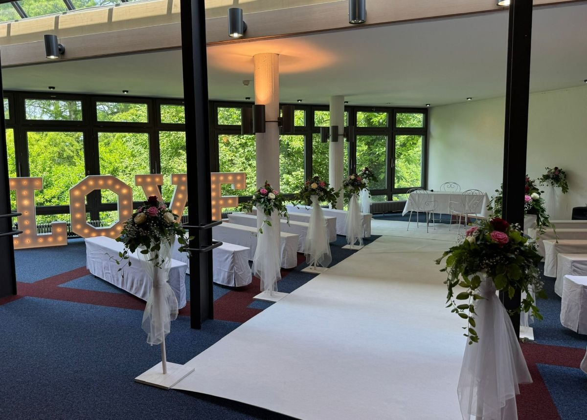 Freie Trauung im Wintergarten des Kurhauses Bad Krozingen mit Blumenschmuck und weißen Stühlen – festliche Hochzeitslocation im Breisgau.