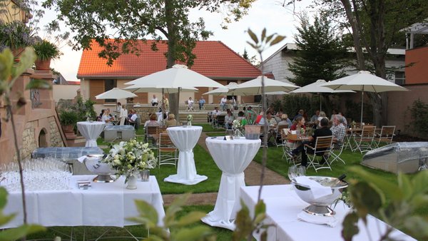 Empfang mit weißen Stehtischen im idyllischen Weingarten des GUT LEBEN am Morstein in Rheinhessen.