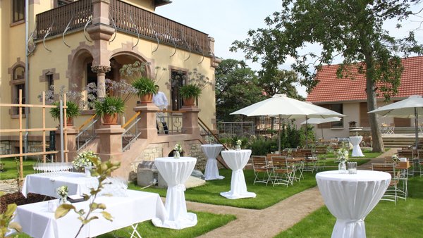 Blick auf den Garten vor der historischen Villa des GUT LEBEN am Morstein bei sonnigem Wetter.
