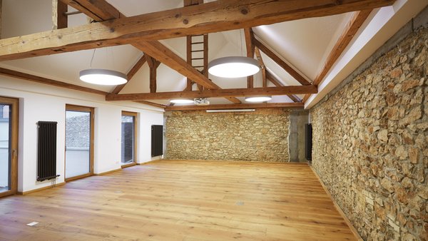 Heller Raum für Hochzeitsfeiern im GUT LEBEN am Morstein mit freigelegten Steinwänden und Holzbalken.