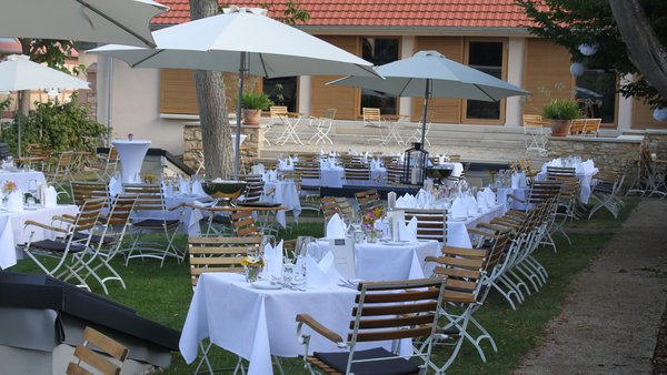 Sommerliche Abendstimmung mit gedeckten Tischen im Außenbereich von GUT LEBEN am Morstein.