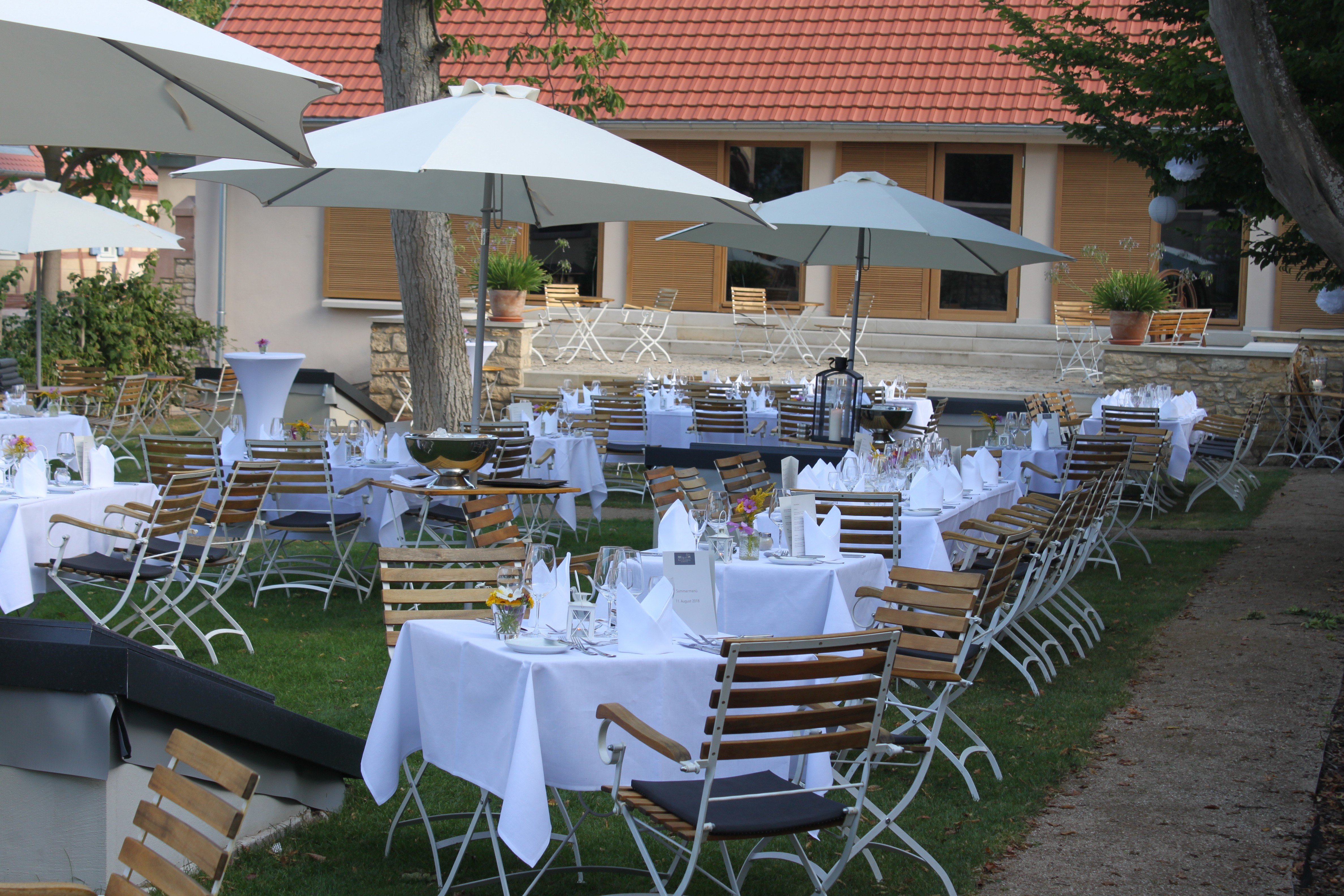 Sommerliche Abendstimmung mit gedeckten Tischen im Außenbereich von GUT LEBEN am Morstein.