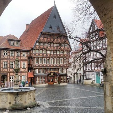 Blick durch einen Steinbogen auf den historischen Marktplatz in Hildesheim mit Knochenhauer-Amtshaus