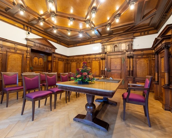 Innenansicht von dem historischen Trauzimmers mit edlen Holzvertäfelungen und mit kunstvoll gearbeitete Kassettendecke im Rathaus Freiburg