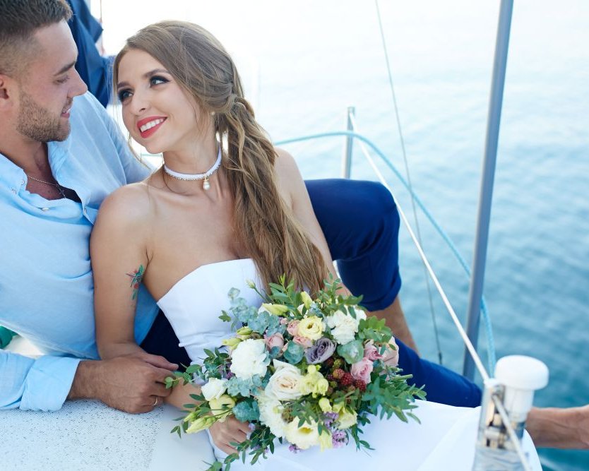 Hochzeit auf dem Schiff – Brautpaar mit Brautstrauß auf dem Deck bei sonnigem Wetter