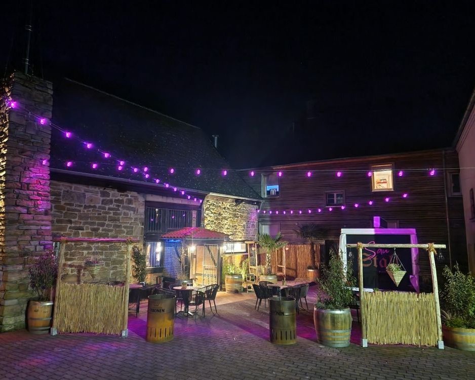 Außenbereich der Hochzeitslocation SauStall Schwerte mit Lichterkette und gemütlicher Abendstimmung