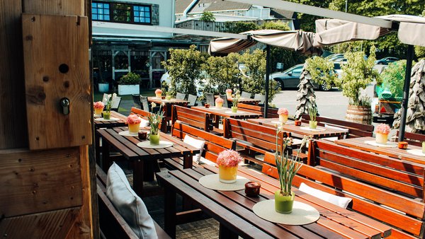 Tische und Sitzbänke im Innenhof der Hochzeitslocation Hotel Sportalm Gipfelglück in Lüdenscheid