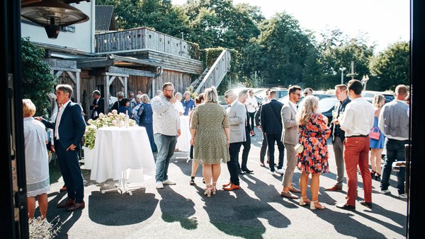 Sektempfang im Freien vor der Hochzeitslocation Hotel Sportalm Gipfelglück Lüdenscheid bei sonnigem Wetter