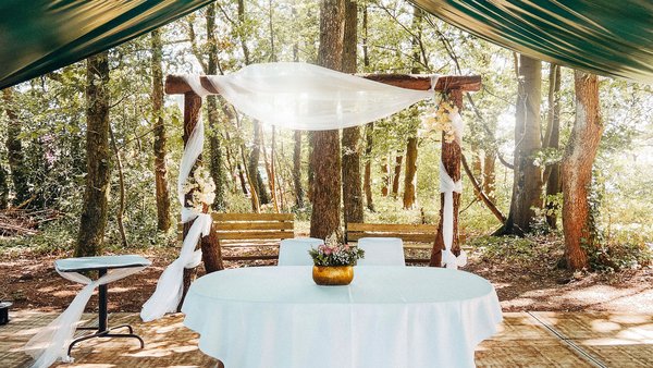 Dekorierter Tisch und Traubogen für freie Trauung in der Hochzeitslocation Sportalm Gipfelglück Lüdenscheid