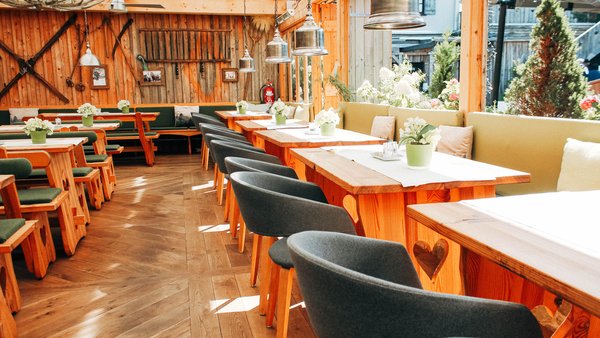 Überdachter Biergarten mit Blick in den Innenhof als Raum zum Feiern in der Hochzeitslocation Hotel Sportalm Gipfelglück