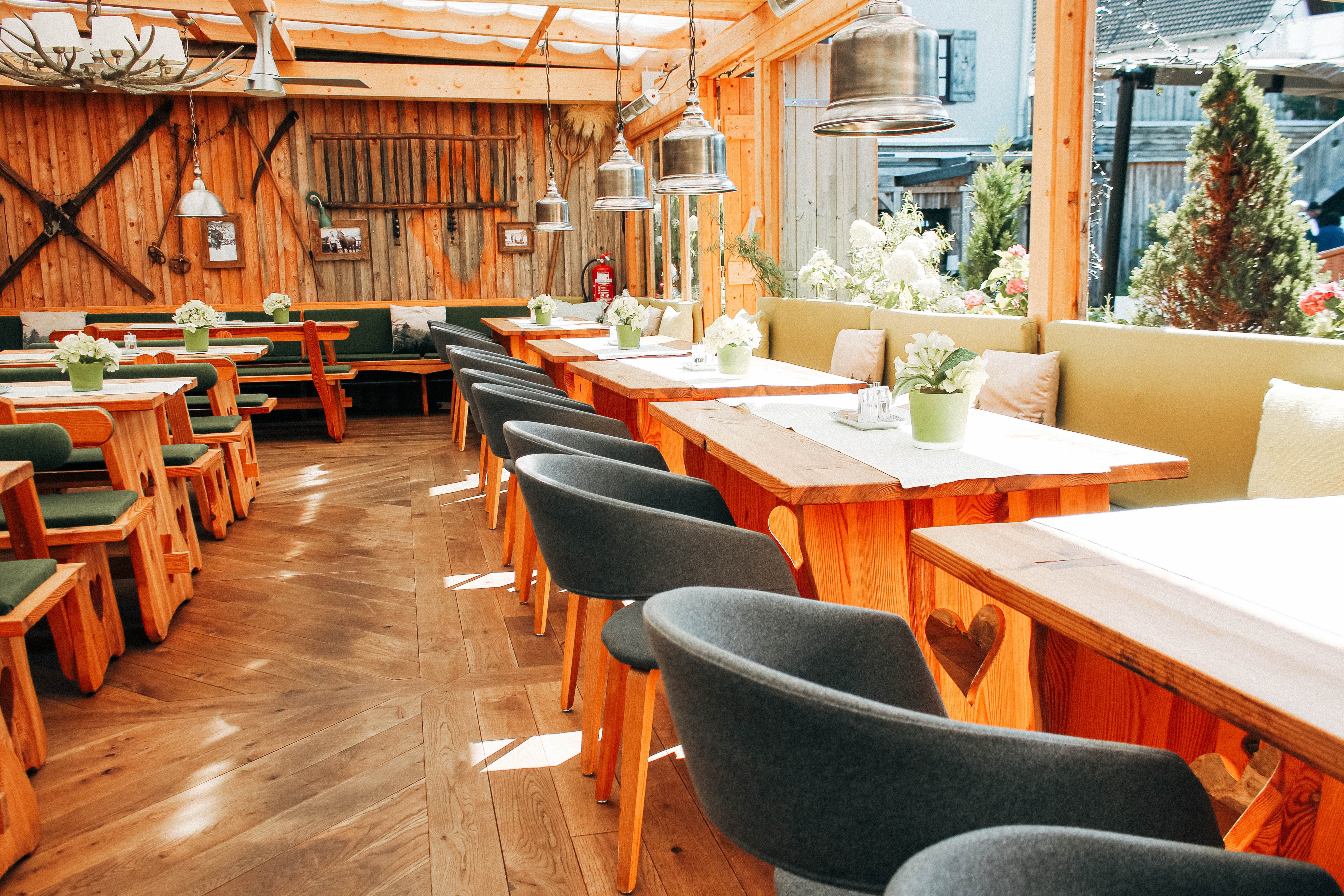 Überdachter Biergarten mit Blick in den Innenhof als Raum zum Feiern in der Hochzeitslocation Hotel Sportalm Gipfelglück