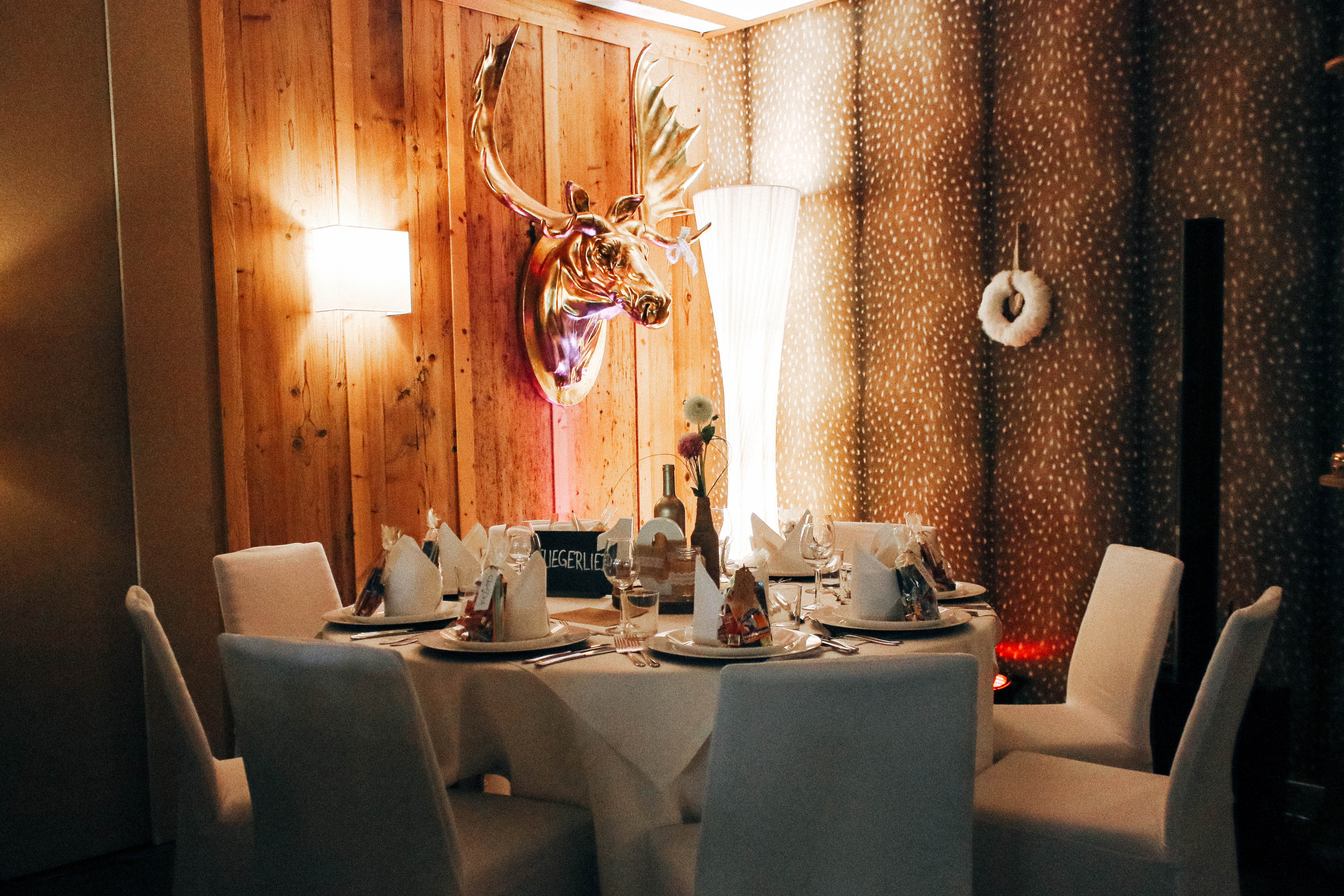Gemütliche und stilvolle Raumausstattung mit gedecktem Tisch für eine Hochzeit im Hotel Sportalm Gipfelglück Lüdenscheid