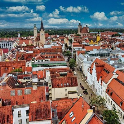 Blick von oben über die historische Altstadt von Ingolstadt mit ihren markanten roten Dächern und Kirchtürmen.