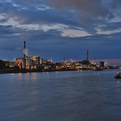 Blick über den Rhein auf die beleuchtete Kulisse von Ludwigshafen bei Nacht.