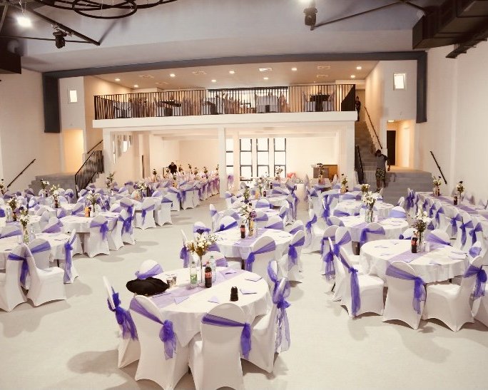 Festlich dekorierter Hochzeitssaal der Palazio Eventlocation in Wuppertal mit Empore und runden Tischen