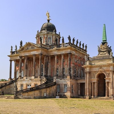 Prachtvoller Barockbau mit Kuppel und großen Säulengängen im Park Sanssouci in Potsdam an einem sonnigen Tag.
