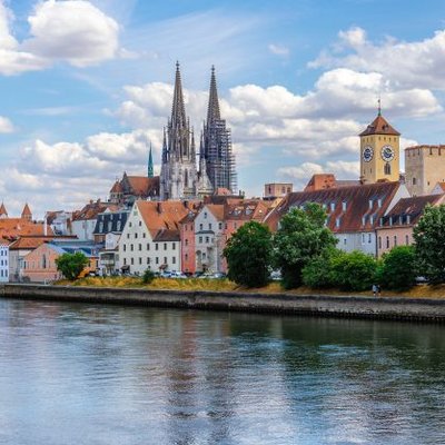 Blick über die Donau auf die historische Altstadt mit den markanten Türmen des Regensburger Doms.