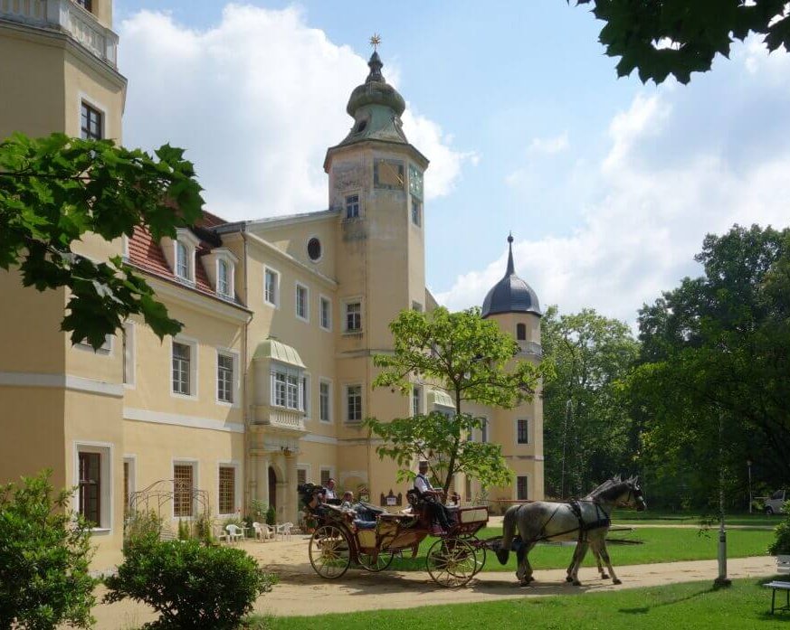 Außenansicht von Schloss Hermsdorf bei Dresden mit romantischer Hochzeitskutsche im Vordergrund