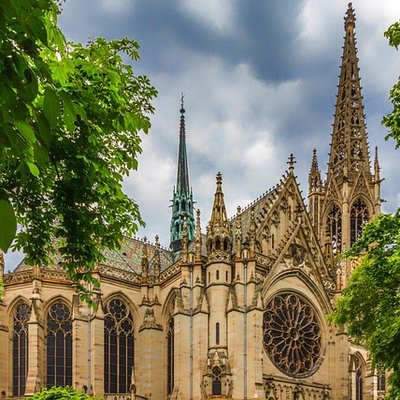 Die historische Gedächtniskirche in Speyer umgeben von grünen Bäumen.