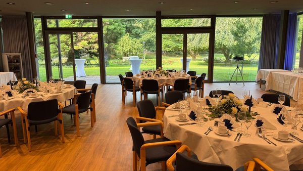 Festlich gedeckter Hochzeitsraum mit Blick in den Kurpark von Bad Krozingen.