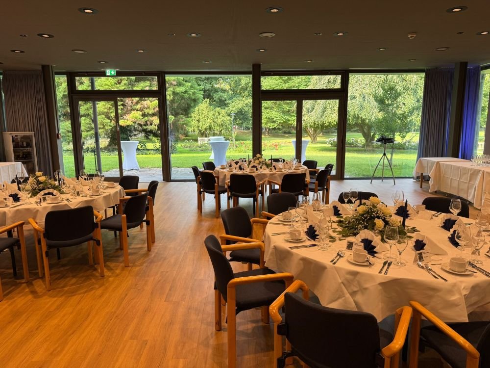 Festlich gedeckter Hochzeitsraum mit Blick in den Kurpark von Bad Krozingen.