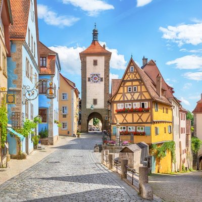 Das berühmte historische Plönlein in Rothenburg ob der Tauber in Franken mit malerischen Fachwerkhäusern unter blauem Himmel.