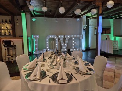 Festlich gedeckter Hochzeitstisch und leuchtende LOVE-Deko in der Hochzeitslocation