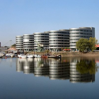 oderne Architektur der Five Boats und ein historischer Hafenkran im Duisburger Innenhafen