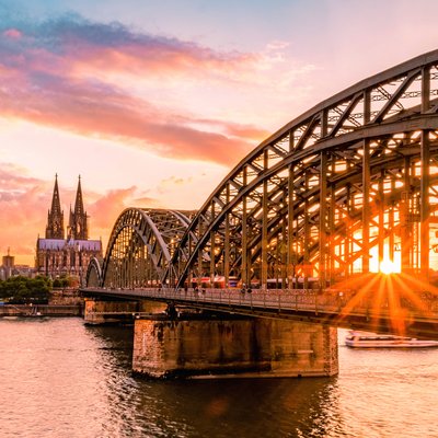 Die Hohenzollernbrücke und der Kölner Dom am Rhein während des Sonnenuntergangs
