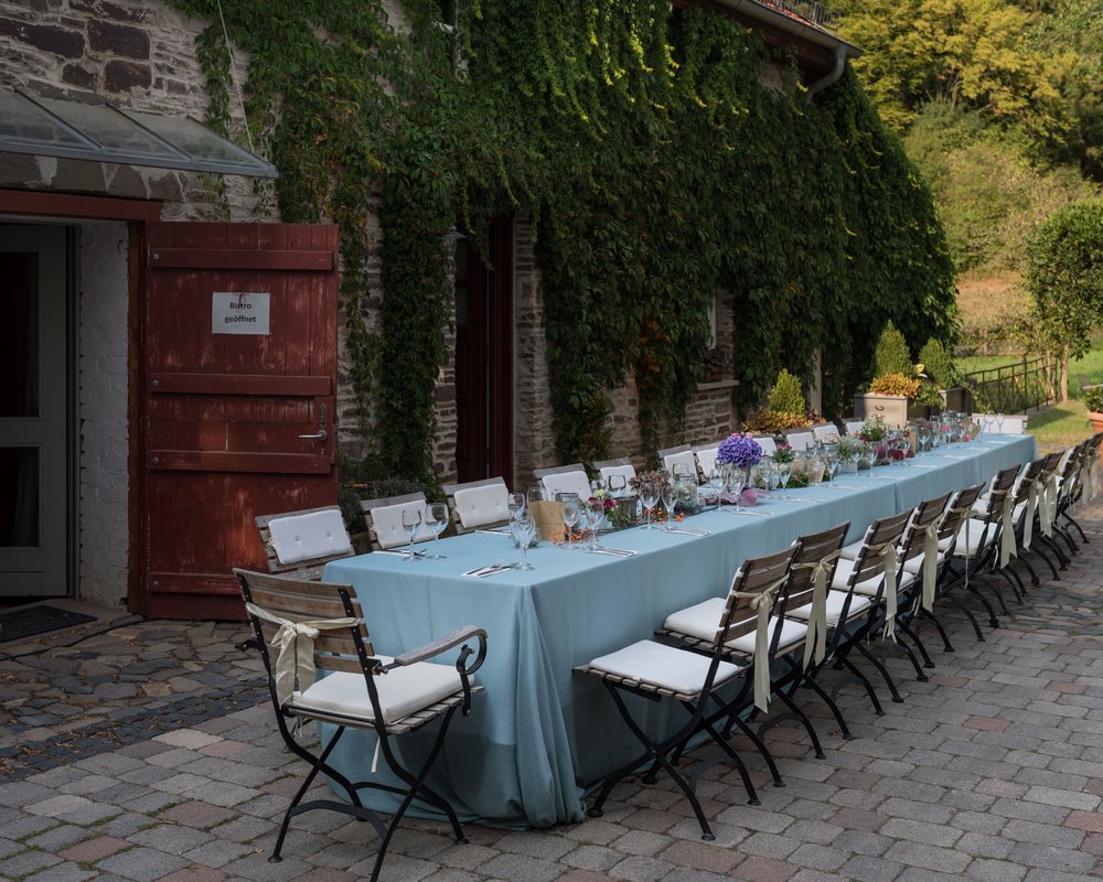 Gedeckte Tafel im Außenbereich der Hochzeitslocation Landhaus Bärenmühle in Frankenau