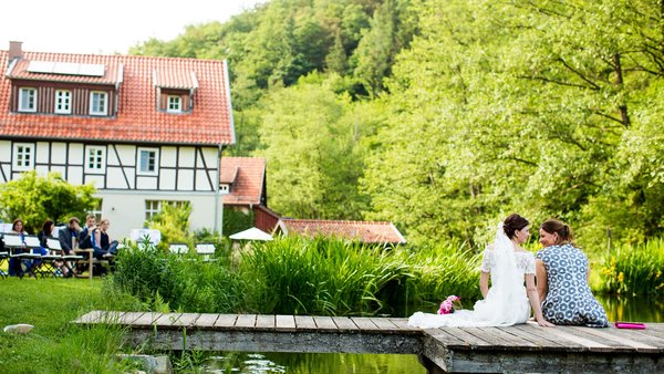 Kurze Auszeit für die Braut auf dem Steg der Hochzeitslocation Landhaus Bärenmühle