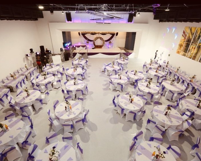 Hochzeitssaal der Palazio Eventlocation Wuppertal mit Bühne und violetter Dekoration